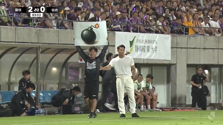 J2球队藤枝MYFC在首轮比赛中，通过场边举图片向场上球员传递战术